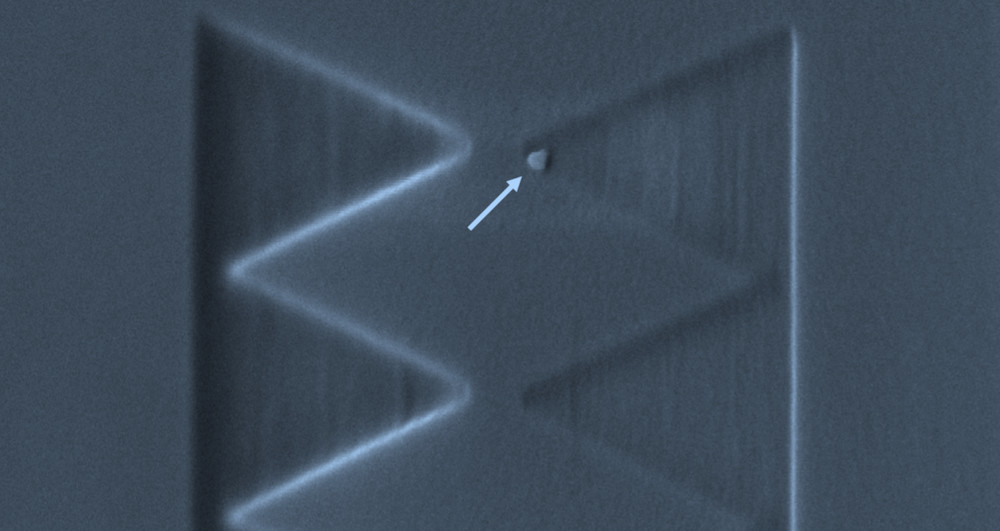Electron microscopy image of a single qubit of about 50 nanometre size (indicated by the arrow) positioned with nanometre-scale precision on a silicon wafer surface. Electron microscopy image of a single qubit of about 50 nanometre size (indicated by the arrow) positioned with nanometre-scale precision on a silicon wafer surface.