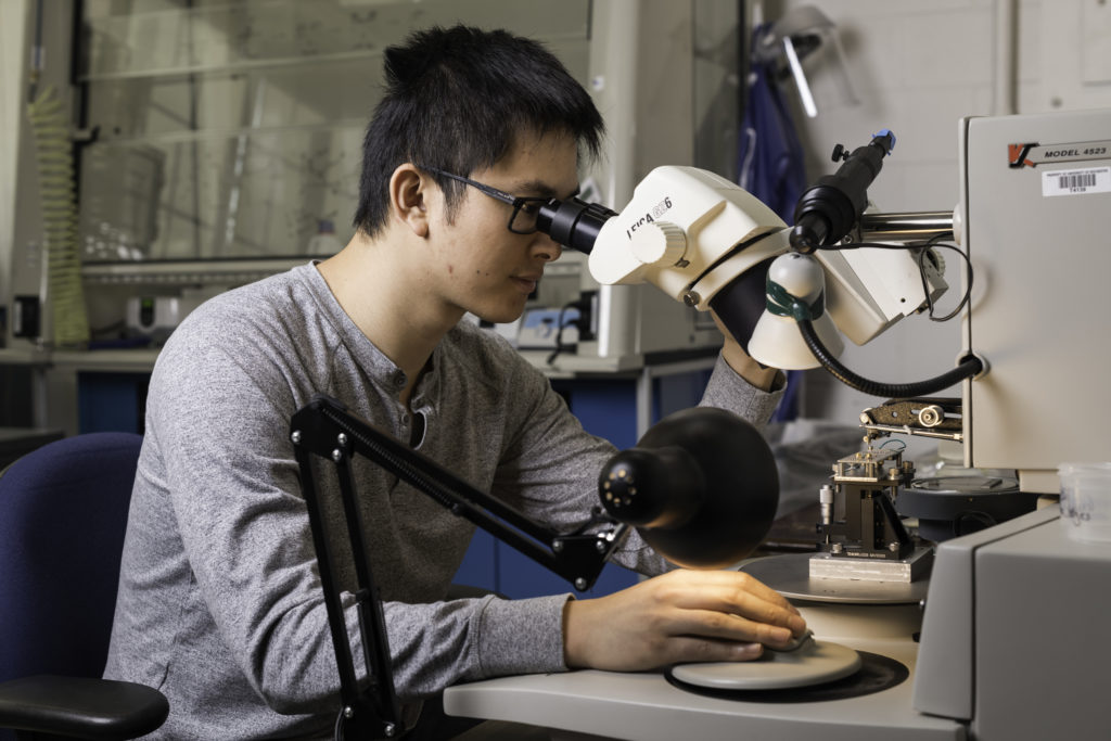 Doctoral student Haifeng Qiao uses a wire bonder to make electrical contact between the circuit board and the experimental device. (University of Rochester photo / J. Adam Fenster) Doctoral student Haifeng Qiao uses a wire bonder to make electrical contact between the circuit board and the experimental device. (University of Rochester photo / J. Adam Fenster)