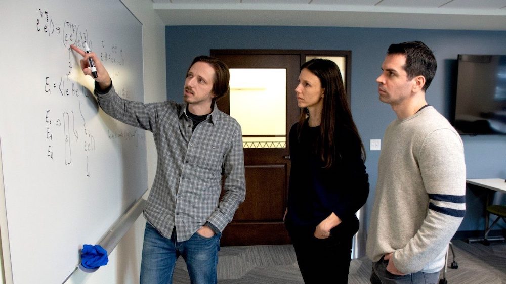 Left to right, Nick Mayhall, Sophia Economou, and Ed Barnes, all researchers and faculty members in the Virginia Tech College of Science, discuss quantum computing algorithms. Photo Virginia Tech.