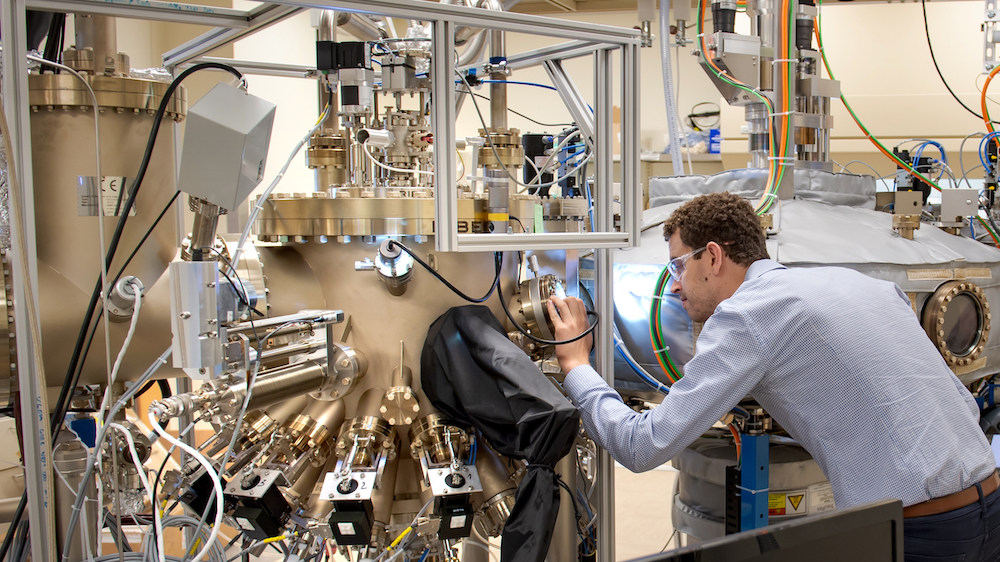 University of Chicago PhD graduate Sam Whiteley examines the sample chamber of Argonne’s Riber molecular beam epitaxy tool, which grows materials that host quantum defects. Sam will join Chicago Quantum Exchange corporate partner HRL Laboratories in August 2019. Photo courtesy of Argonne National Laboratory.