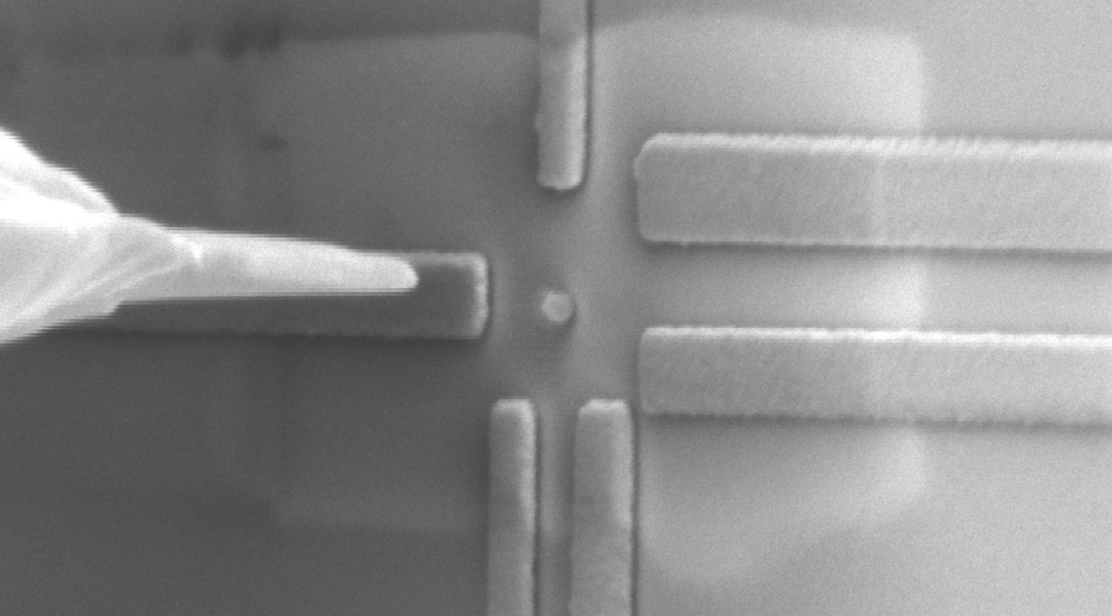 A single qubit component undergoing direct quantum measurements related to the materials’ electronic characteristics, with the qubit component observed in the centre of the image (round particle of about 50 nanometres in size) and surrounded by rectangular nanoelectrodes prepared using facilities at the University.